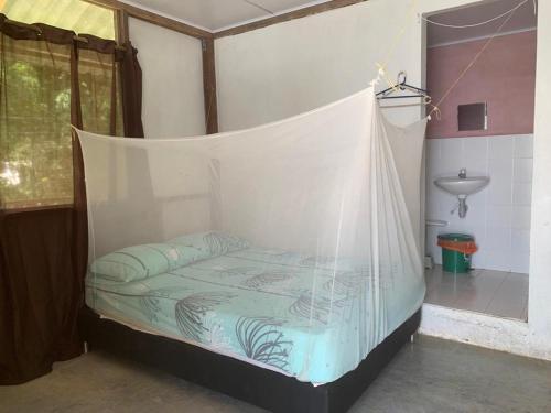 a bed in a room with a mosquito net at Hostal El Chileno Sapzurro in Sapzurro