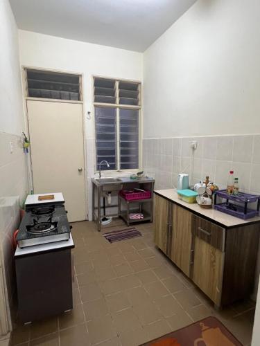 uma cozinha com um lavatório e um fogão em Mama Homestay em Kampong Jubakar Pantai