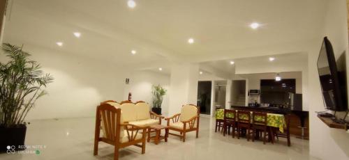 ein Wohnzimmer mit Stühlen und einem Tisch sowie eine Küche in der Unterkunft Killamoon House Paracas in Paracas
