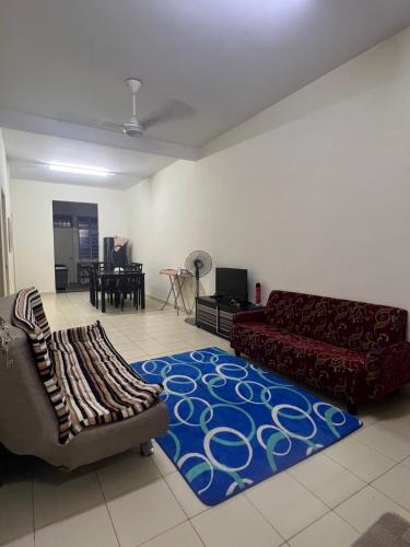 una sala de estar con 2 sofás y una alfombra azul en Mama Homestay, en Kampong Jubakar Pantai