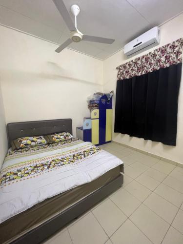 een slaapkamer met een bed en een plafondventilator bij Mama Homestay in Kampong Jubakar Pantai