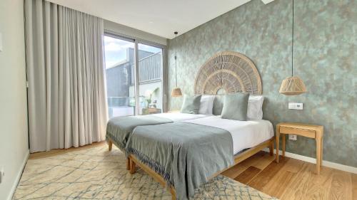 a bedroom with a bed and a large window at Villa Obra-Prima by LovelyStay in Funchal