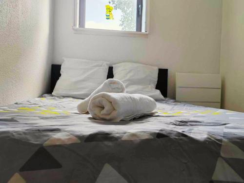 a towel animal laying on top of a bed at T2 - au coeur de la roche in La Roche-sur-Yon