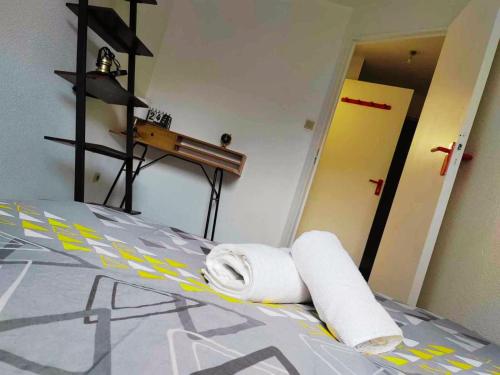 ein Schlafzimmer mit einem Bett mit Handtüchern darauf in der Unterkunft T2 - au coeur de la roche in La Roche-sur-Yon