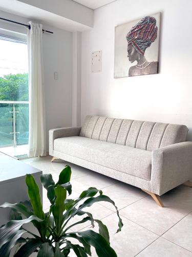 un salon avec un canapé et une plante dans l'établissement Apartamento 202 Entero, à Montería