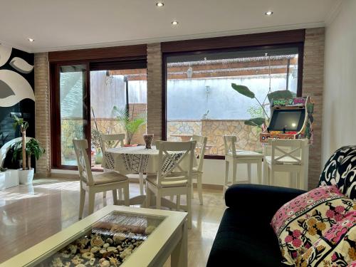 ein Wohnzimmer mit einem Tisch und Stühlen sowie einem TV in der Unterkunft Casa con jacuzzi y piscina con vistas al castillo in Corbera de Alcira