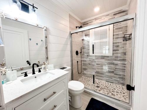La salle de bains est pourvue d'une douche, de toilettes et d'un lavabo. dans l'établissement Coastal Bungalow - NEW 2 Bedrooms - Mt Pleasant, à Charleston