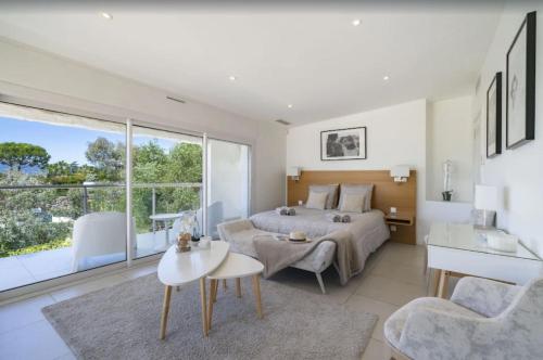 um quarto com uma cama, uma mesa e um sofá em FRGK "Beautiful contemporary villa, with splendid panoramic sea view" em Cannes