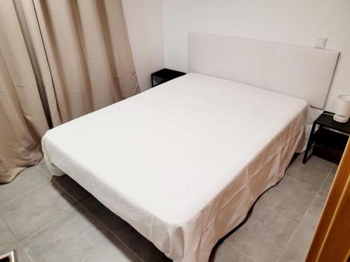 a white bed in a small room with aermott at Penedo Grande suítes T2 dúplex in São Bartolomeu de Messines