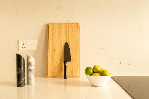 a knife block and a bowl of fruit on a counter at Modern 3BD Spacious Apartment with Terrace - Close to Yacht Marina in Msida
