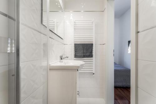 a white bathroom with a sink and a shower at Opera Luxury Studio Apartment in Budapest