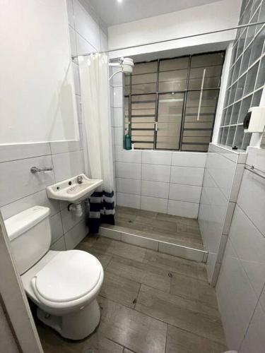 ein weißes Bad mit einem WC und einem Waschbecken in der Unterkunft Departamento con vista a la Plaza in Cajamarca