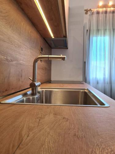a kitchen with a stainless steel sink and a window at Cento Blu Villa in Gouvia