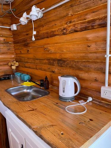 una encimera de cocina con fregadero en una cabaña de madera en Rincón del Sur en San Miguel del Monte