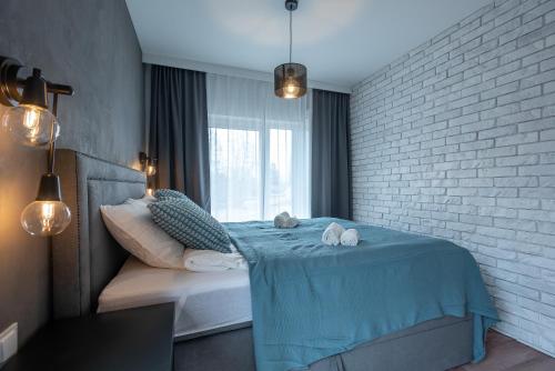 ein Schlafzimmer mit einem Bett und einer Ziegelwand in der Unterkunft Apartament 5 StolarSki - 5D Apartments in Szklarska Poręba