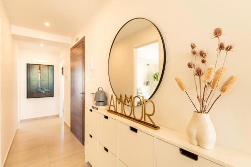 a mirror on a wall above a dresser in a hallway at Modern 3BD Spacious Apartment with Terrace - Close to Yacht Marina in Msida