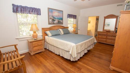 Schlafzimmer mit einem Bett und Holzböden in der Unterkunft Soundside, Lake View, Hot Tub, Dogs Welcome, Community Amenities, VOH56, Atlantic Sound Waves in Corolla