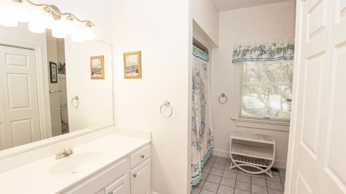 ein weißes Badezimmer mit Waschbecken und Spiegel in der Unterkunft Soundside, Lake View, Hot Tub, Dogs Welcome, Community Amenities, VOH56, Atlantic Sound Waves in Corolla