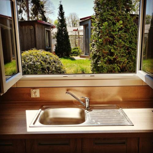 a kitchen sink in front of a window at OW Plaża Klub domki in Dziwnów