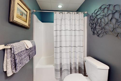 y baño con aseo y cortina de ducha. en Whispering Sands 301, en Ocean City