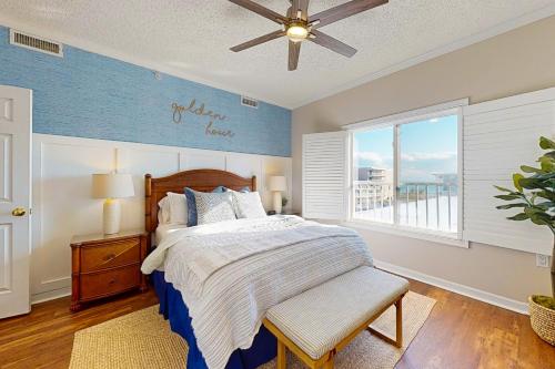 a bedroom with a bed with a ceiling fan and a window at Whispering Sands 301 in Ocean City