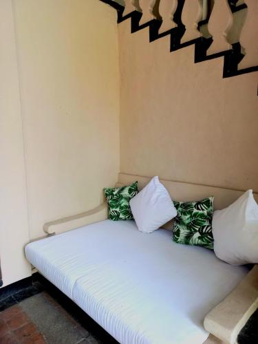 a white bed with four pillows on it at Il Piccolo Peccato in Cuernavaca