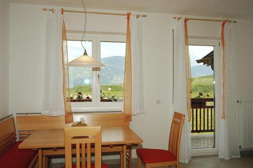 comedor con mesa y ventana en Georgshof, en Appiano sulla Strada del Vino