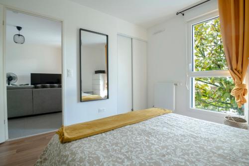 - une chambre avec un grand lit et un miroir dans l'établissement T2 cosy Bordeaux - tram & parking, à Cenon