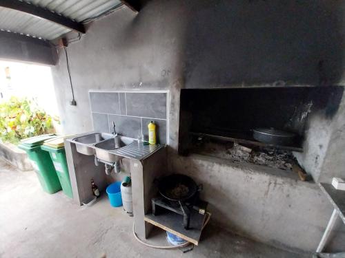 uma cozinha com um lavatório e um fogão em Ti kaz anturium em La Possession