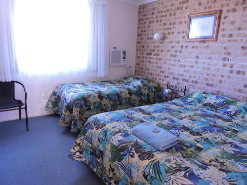 A bed or beds in a room at Bulahdelah Myall Motel