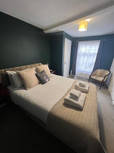 a bedroom with a large bed with two towels on it at The Bell Inn, Rickinghall in Rickinghall