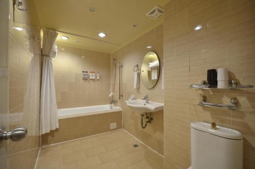 a bathroom with a toilet and a sink and a shower at Goodness Hotel in Kaohsiung