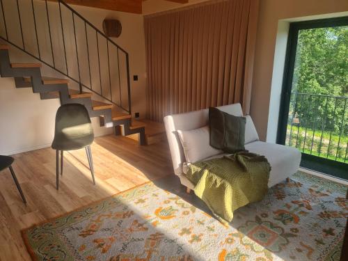 a living room with a chair and a staircase at Ermo Loft - Casas do Ermo in Fafe