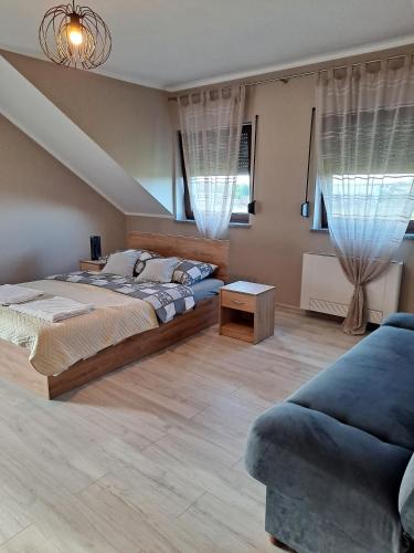 a large bedroom with a bed and a couch at Złote Gąski in Gąski