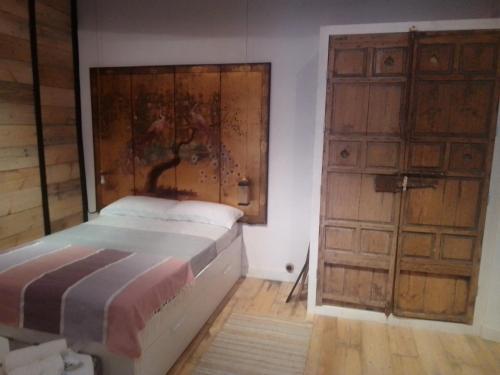a bedroom with a bed and two wooden doors at La gota de leche 2 in Sanlúcar de Barrameda
