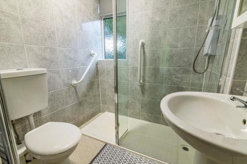 y baño con ducha, aseo y lavamanos. en 2 bed home Walking distance to QMC en Nottingham