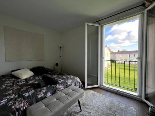 a bedroom with a bed and a large window at Évasion Forestière : Confort et Moderne in Samois-sur-Seine