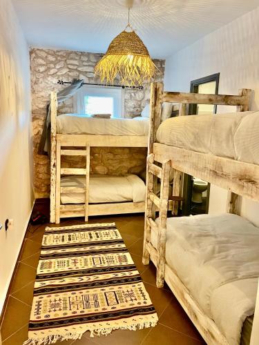 a room with four bunk beds and a chandelier at Chill House surf camp in Sidi Kaouki