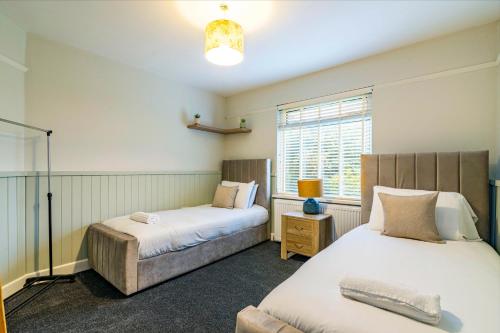 1 dormitorio con 2 camas y ventana en 2 bed home Walking distance to QMC en Nottingham