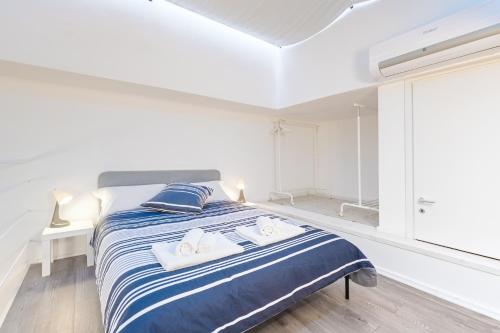 Un dormitorio blanco con una cama con toallas. en Exclusive Loft Crocetta - Free Private Parking & Wi-Fi - 5 min To Metro Nizza, en Turín