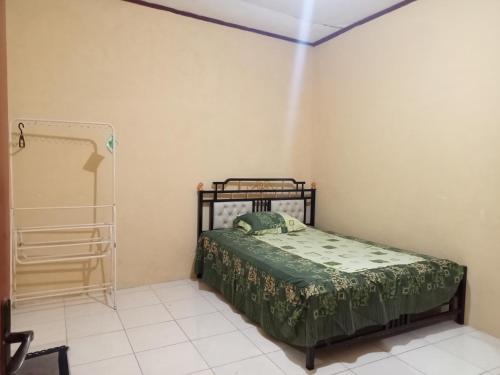 um quarto com uma cama num quarto em Penginapan Syari'ah Parak Anau em Tabing