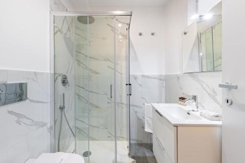 baño blanco con ducha y lavamanos en Exclusive Loft Crocetta - Free Private Parking & Wi-Fi - 5 min To Metro Nizza, en Turín