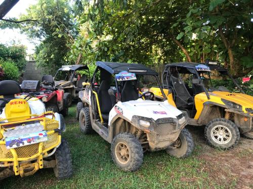 a group of four atvs and tractors parked in the grass at Hotel le Lagon in Foulpointe