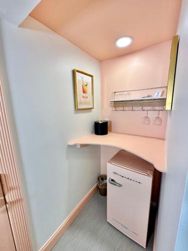 a small kitchen with a shelf and a refrigerator at Peninsula Bed & Cocktails in St Petersburg