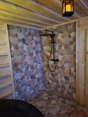 a shower in a room with a stone wall at Apartments Beskydy in Prostřední Bečva
