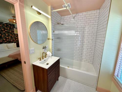 La salle de bains est pourvue d'un lavabo, d'une baignoire et d'un miroir. dans l'établissement Peninsula Bed & Cocktails, à St Petersburg