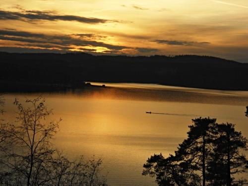 a sunset over a lake with a boat in the water at Mlýn Kamenice in Klučenice