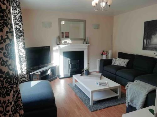 a living room with a couch and a fireplace at Beside the Seaside Tynemouth in Cullercoats