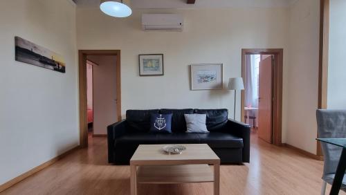 a living room with a black couch and a table at Lightoasis Oeiras 4 in Oeiras