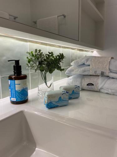 a bathroom counter with a sink and a bottle of soap and towels at Lagoa relax in Rio de Janeiro